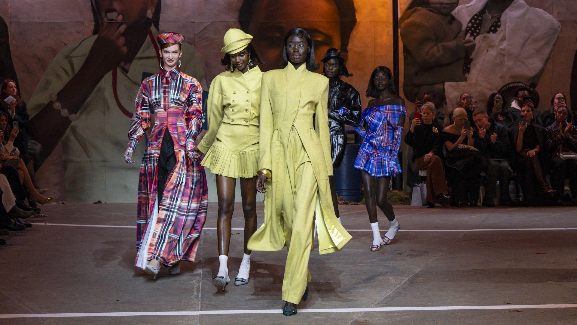Designers and models at the end of a fashion runway, reference image from the Between the Seasons project document